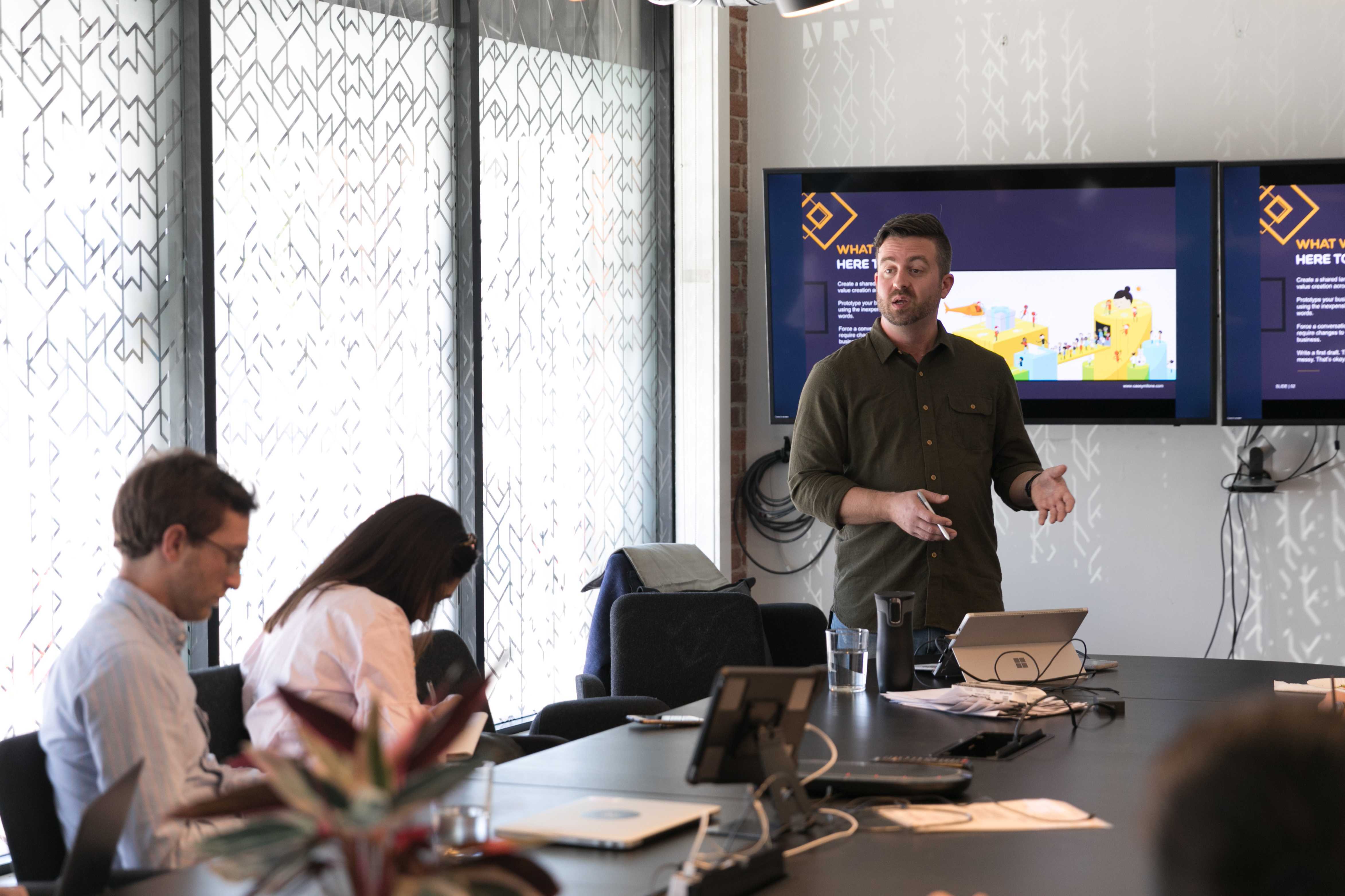 Casey leading a workshop in a boardroom setting